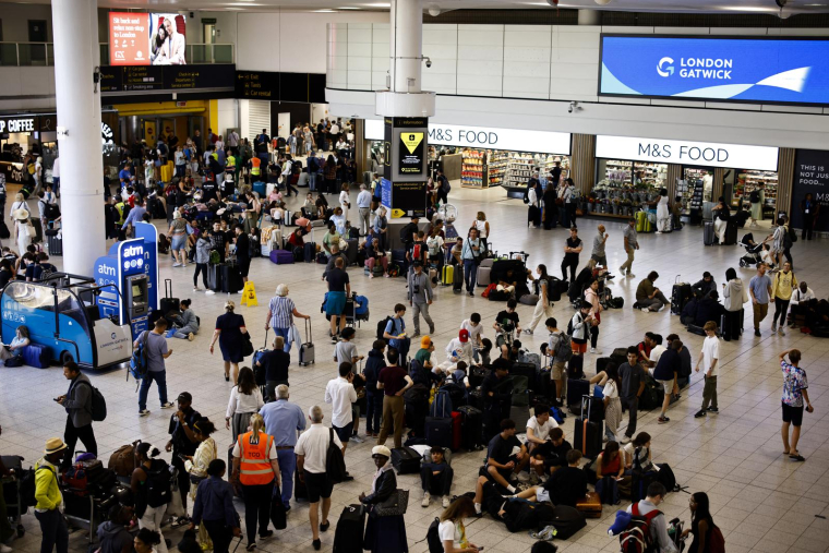 Des voyageurs attendent à l'aéroport de Gatwick alors que des vols sont annulés ou retardés en raison d'une panne informatique mondiale, le 19 juillet 2024 au Royaume-Uni. ( AFP / BENJAMIN CREMEL )